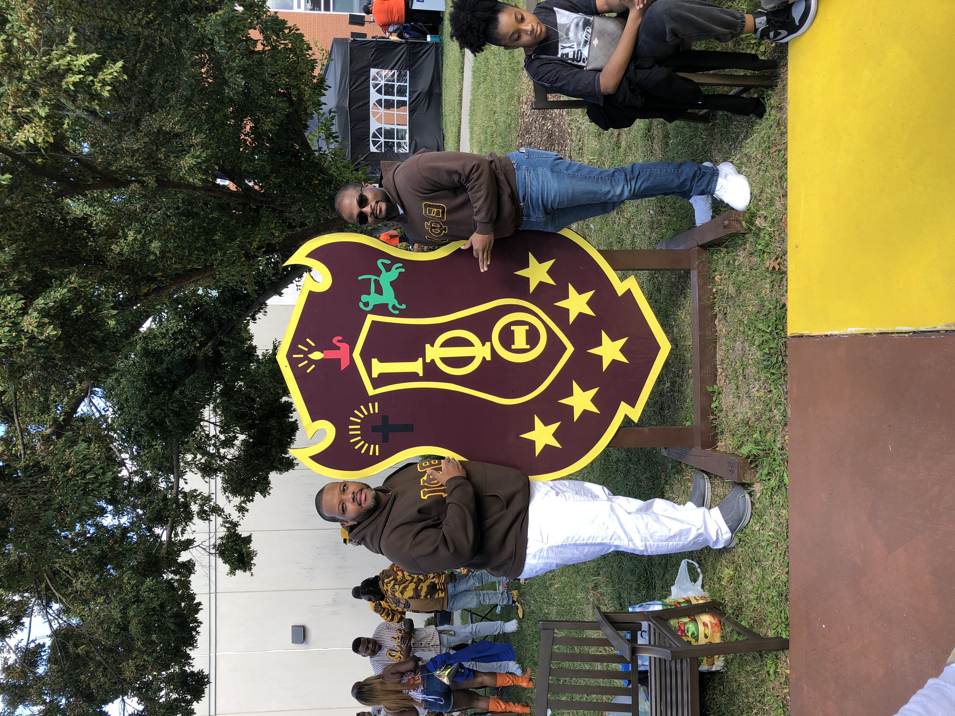 Brothers reconnect on campus with the Iota Phi Theta shield.